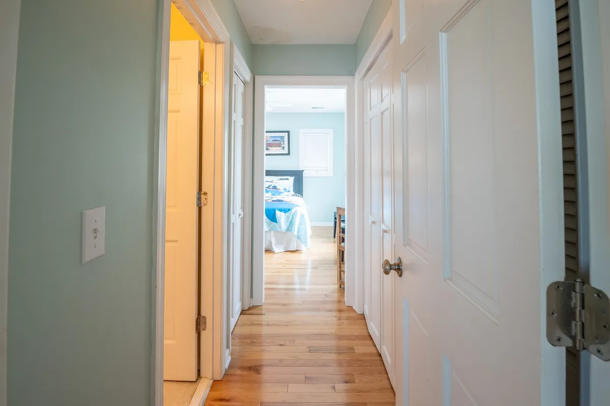 A welcoming hallway lined with multiple doorways and the entrance to a bedroom. The hallway is bright and inviting, suggesting easy access to different living areas for family members of all ages.